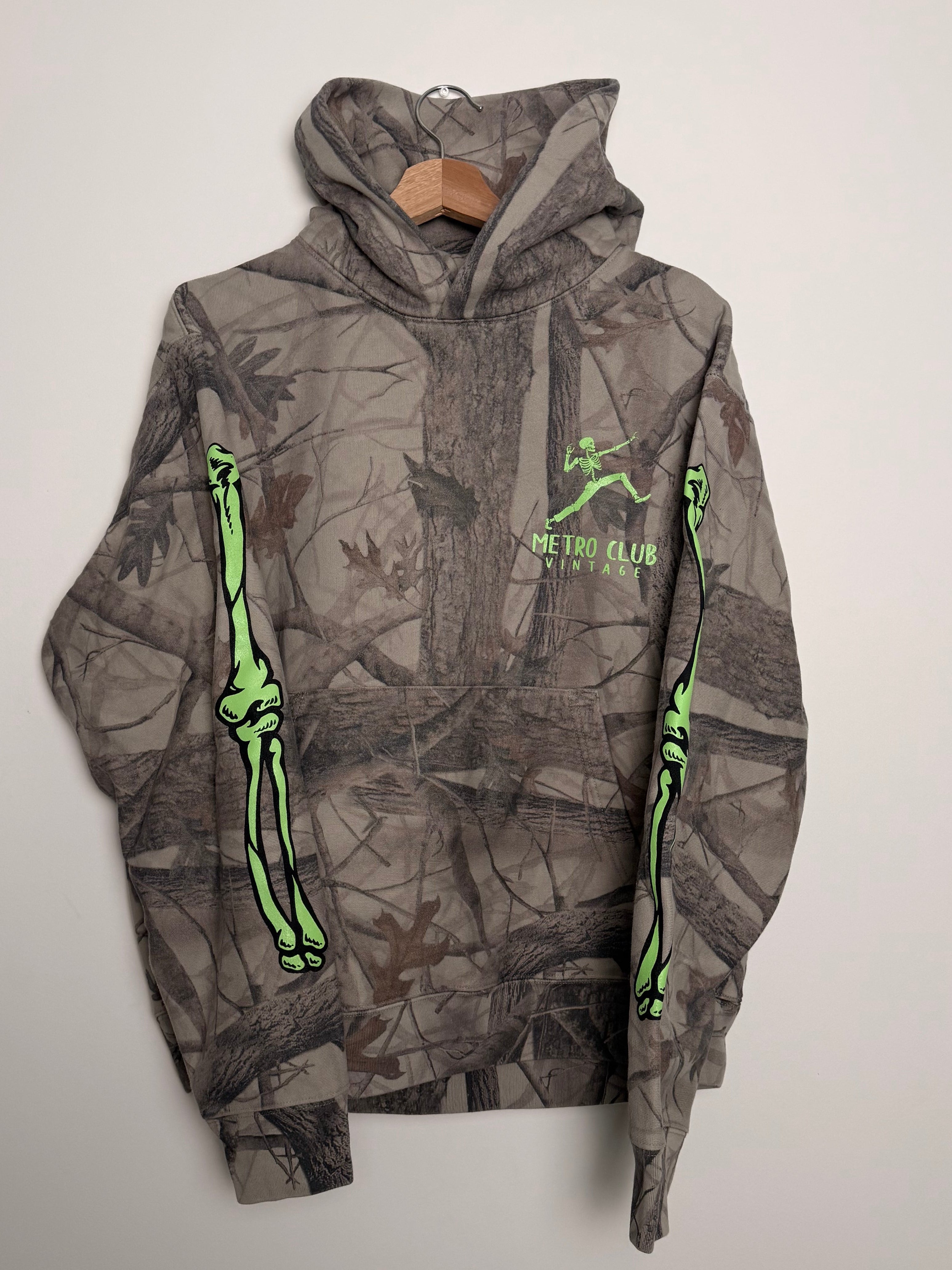 Gray camouflage hoodie with green accents on a light gray background